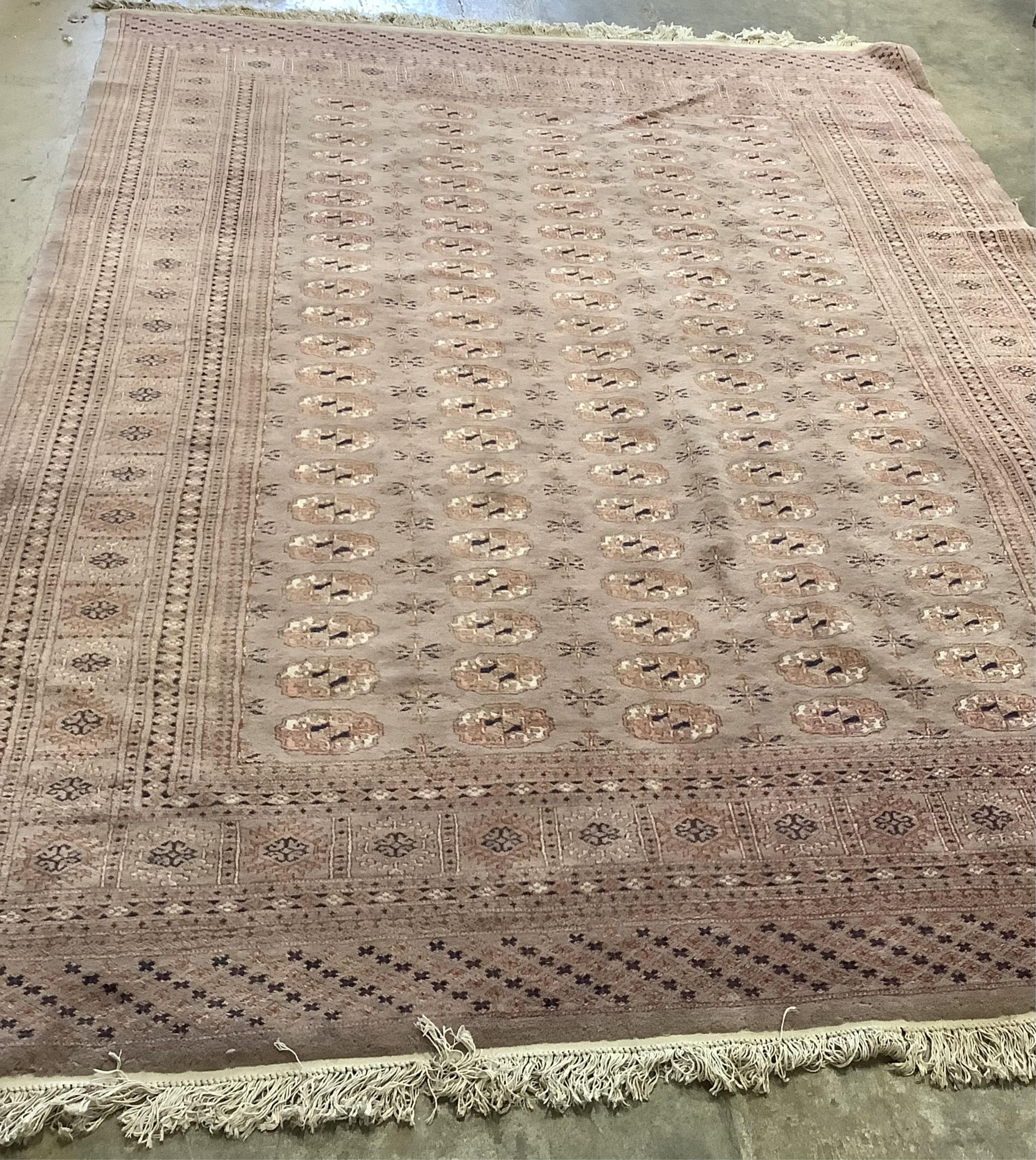 A Bokhara peach ground carpet, 320 x 215cm. Condition - poor to fair